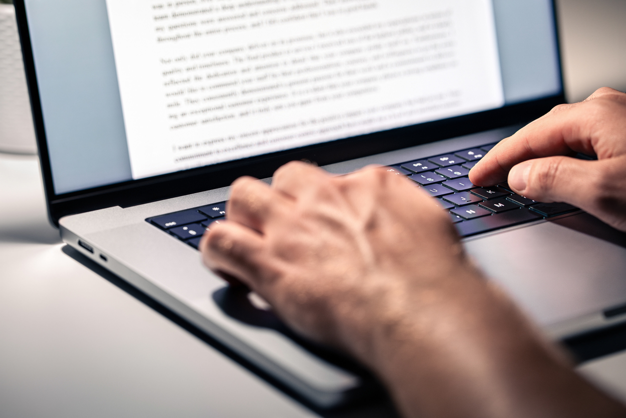 Close-up of a student typing an essay on a laptop